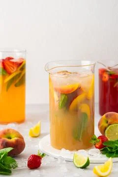 Jugs of refreshing fruit drinks with fruit wedges Stock Photos