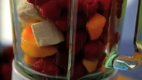 Juice being added to blender full of fruit and then blended Stock Footage 98247735
