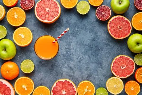Juice with citrus fruit, apple, grapefruit on blue background. Top view Stock Photos