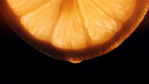 Juice dripping from a slice of lemon - close-up Stock Footage 127853537