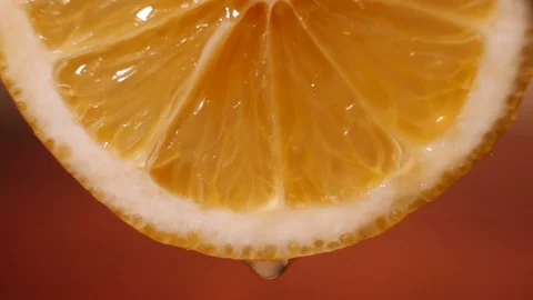 Juice dripping from a slice of orange, macro video. Bright juicy pulp of citrus  Video stock 126322214