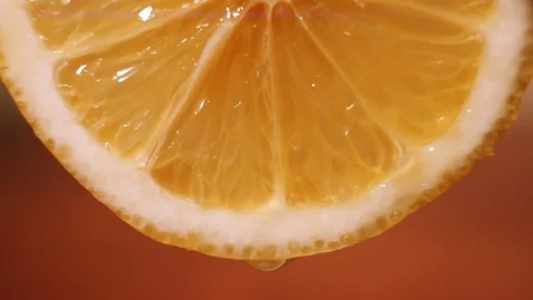 Juice dripping from a slice of orange, macro video. Bright juicy pulp of citrus Stock Footage 127852156