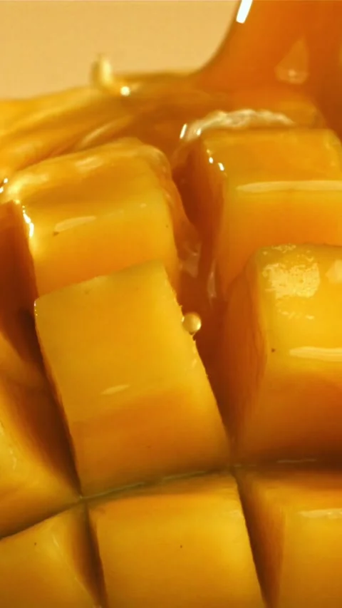 The juice flows through the sliced mango fruit. Filmed on a high-speed camera at 스톡 동영상 335307435