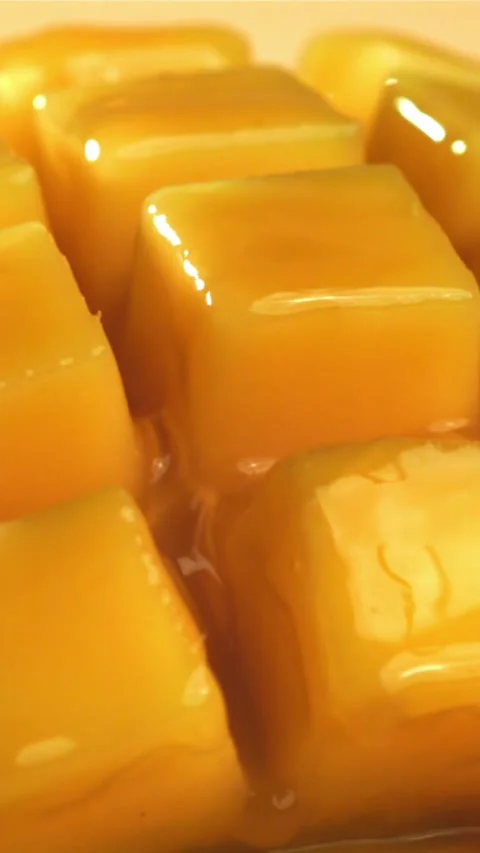 The juice flows through the sliced mango fruit. Filmed on a high-speed camera at Stock Footage 335316769