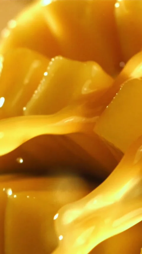 The juice flows through the sliced mango fruit. Filmed on a high-speed camera at Stock Footage 335319491