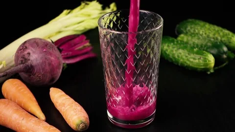 Juice from fresh vegetables, carrots, celery, beets and cucumbers. High speed Stock Footage 74660022