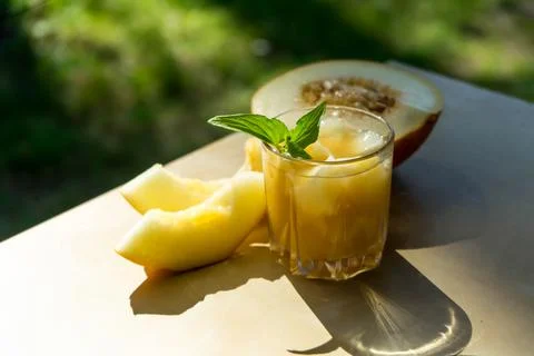 The juice of melon with mint in a glass jar on the table.Hami melon Stock Photos