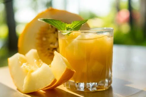 The juice of melon with mint in a glass jar on the table.Hami melon Stock Photos