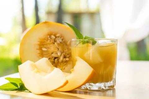 The juice of melon with mint in a glass jar on the table.Hami melon Stock Photos