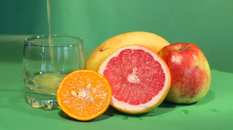 The juice is poured into a glass. back of grapefruit, mandarin, banana, apple Stock Footage 62019101