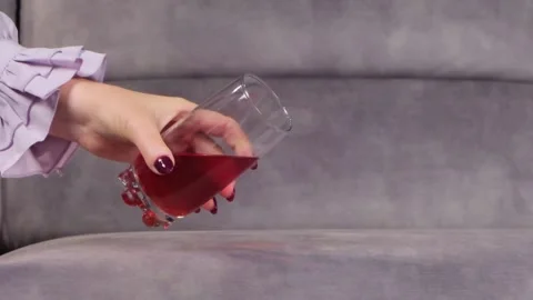 Juice is poured onto a sofa from a glass Stock Footage 130827151