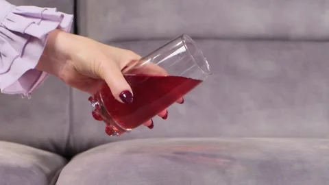 Juice is poured onto a sofa from a glass Video stock 130827911