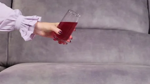 Juice is poured onto a sofa from a glass Video stock 130828385