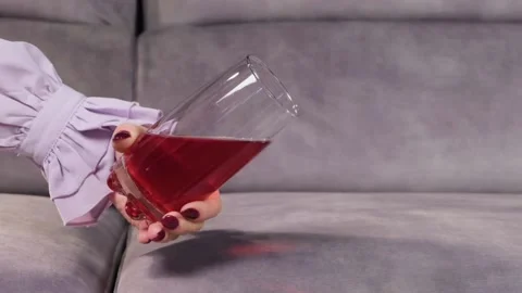 Juice is poured onto a sofa from a glass Stock Footage 130828454
