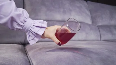 Juice is poured onto a sofa from a glass Stock Footage 130828715