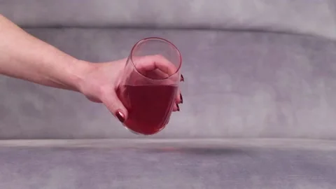Juice is poured onto a sofa from a glass Stock Footage 130828950