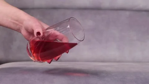 Juice is poured onto a sofa from a glass Stock Footage 130829599
