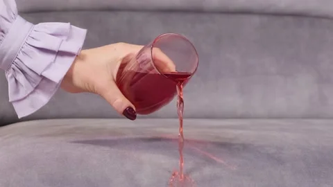 Juice is poured onto a sofa from a glass Stock Footage 130829809