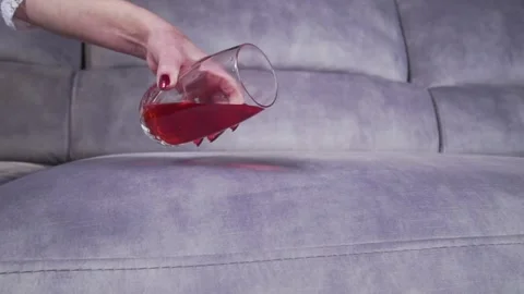 Juice is poured onto a sofa from a glass Stock-Footage 130830036