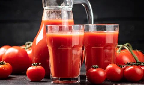Juice from ripe tomatoes on the table. Stock Photos