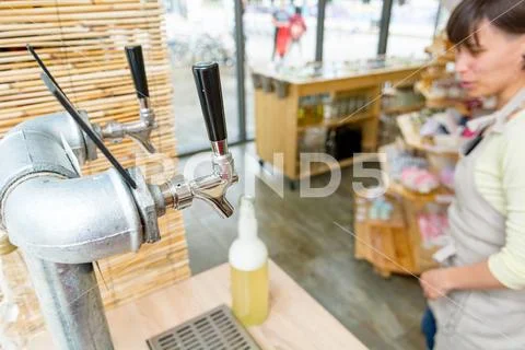 Juice tap for pouring delicious organic bevarage at zero waste store. Stock Photos