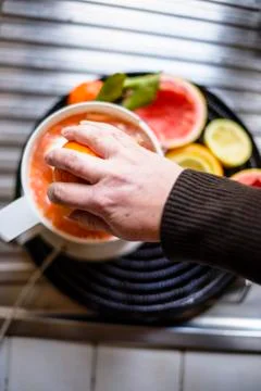Juicer with citrus fruit squeezed in the kitchen Stock Photos