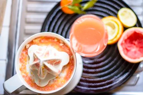 Juicer with citrus fruit squeezed in the kitchen Stock Photos