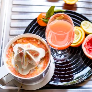 Juicer with citrus fruit squeezed in the kitchen Stock Photos