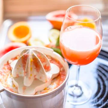 Juicer with citrus fruit squeezed in the kitchen Stock Photos