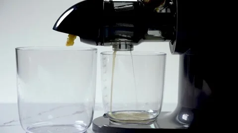 Juicer with two clean glasses positioned to catch fresh juice extraction Stock Footage 306057181