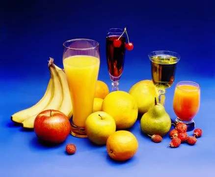 Juices, drinks, fruit  on a blue background Stock Photos