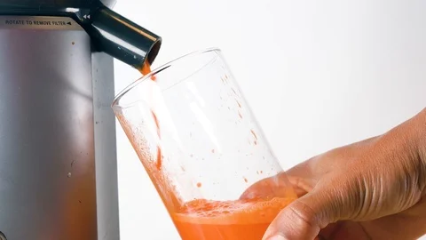 Juicing carrot into cup Stock Footage 124444619
