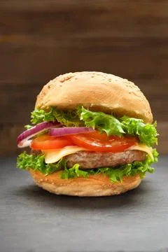 Juicy appetizing burger with beef on a dark background, homemade hamburger,.. Stock Photos