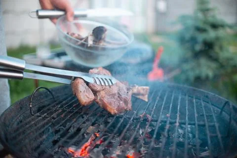 Juicy appetizing steak is fried on the grill during a summer barbecue in nature Stock Photos