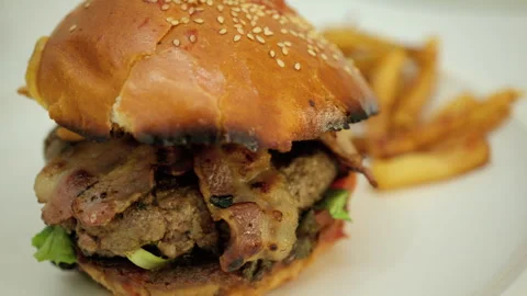 Juicy bacon cheeseburger with beef patty, lettuce, cheese, and sesame bun, Stock Footage 343120774