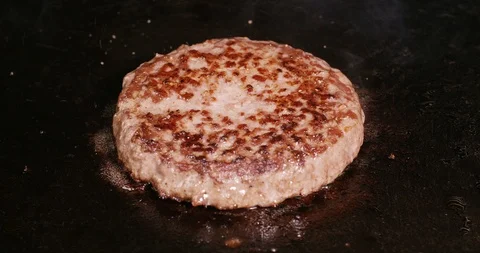 Juicy beef burger is being fried on the hot iron in C4K resolution Video stock 94660598