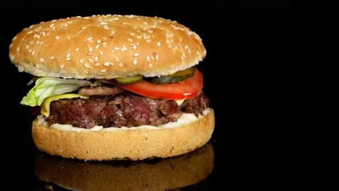 Juicy beef burger, copy space, black background with reflection, loop Stock Footage 75253988