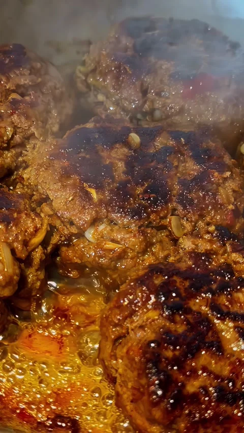 Juicy Beef Burger Patties Sizzling on Hot Grill with Smoke Rising Stock Footage 339752011