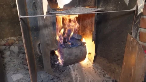 Juicy Beef Steak Grilling Over Open Wood Fire with Roaring Flames and Smoke in a Stock Footage 338210780