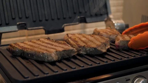 Juicy beef steak overturned with grilled tongs Stock Footage 120148798