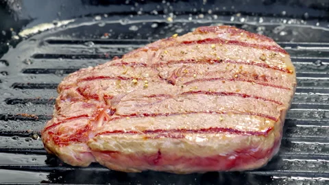 Juicy beef steak with raw center cooked on a cast iron pan. The chef adds pepper Video stock 315904144