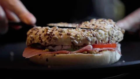 A juicy burger is being cut with a knife, Burger with Melted Cheese Stock Footage 246734285