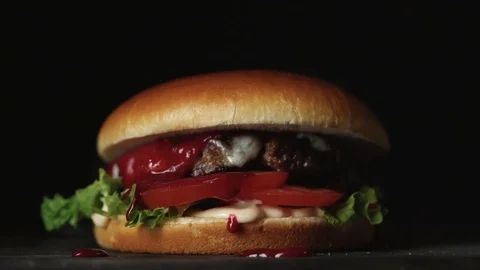 Juicy cheeseburger on black background Stock Footage 121723201