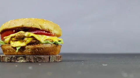 Juicy Cheeseburger With Lettuce Tomato And Melted Cheese On Rustic Wooden Servin Stock Footage 339959973