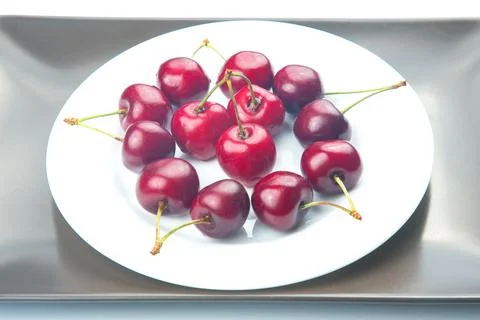 Juicy cherry berries lie on a white plate. healthy food for breakfast. fruits Stock Photos