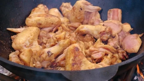 Juicy chicken in a cauldron, slow motion. Appetizing chicken fried in a slow Stock Footage 278926096