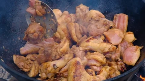 Juicy chicken in a cauldron, slow motion. Appetizing chicken fried in a slow Stock Footage 312804059