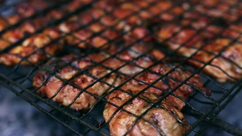 Juicy chicken pieces sizzling on a hot barbecue grill outdoors Stock Footage 340263711