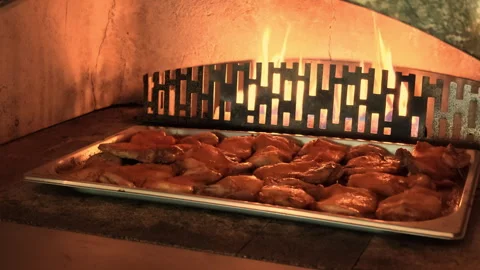 Juicy Chicken Thighs Baking Inside a Wood-Fired Pizza Oven Stock Footage 341467436
