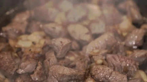 Juicy Cubed Beef Sizzling in Pan with Garlic and Onions Stock Footage 315135641